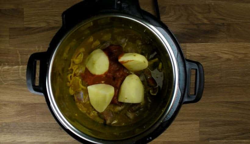 Pressure Cooker Curry Goat Recipe (Instant Pot Goat Curry): add in curry ingredients, goat shoulder, tomato paste, quartered potatoes in Instant Pot Electric Pressure Cooker