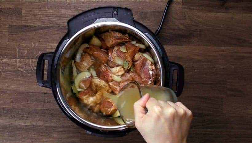 Easy Instant Pot Carnitas Recipe (Pressure Cooker Carnitas): pouring chicken stock in Instant Pot Electric Pressure Cooker