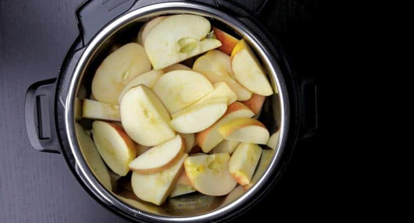 Instant Pot Apple Butter Recipe (Pressure Cooker Apple Butter): place spices and quartered apples in Instant Pot Electric Pressure Cooker.