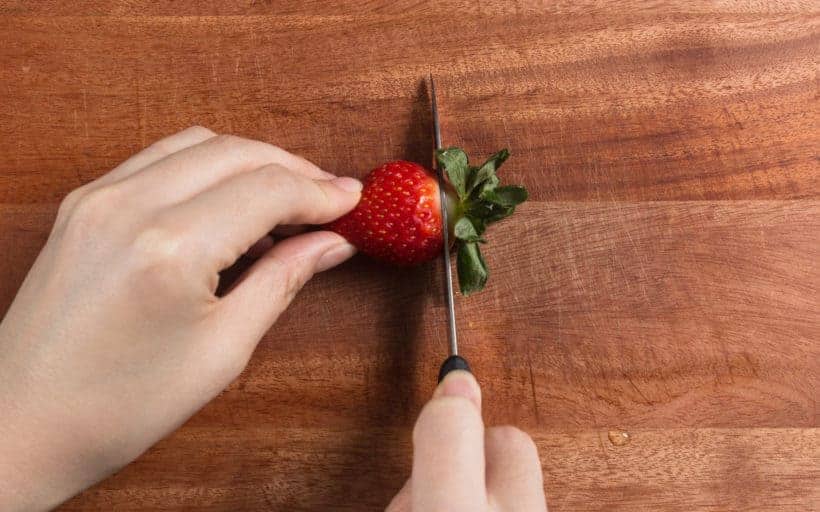 How to make Instant Pot Strawberry Compote Recipe (Pressure Cooker Strawberry Compote): trim the strawberry stems with paring knife